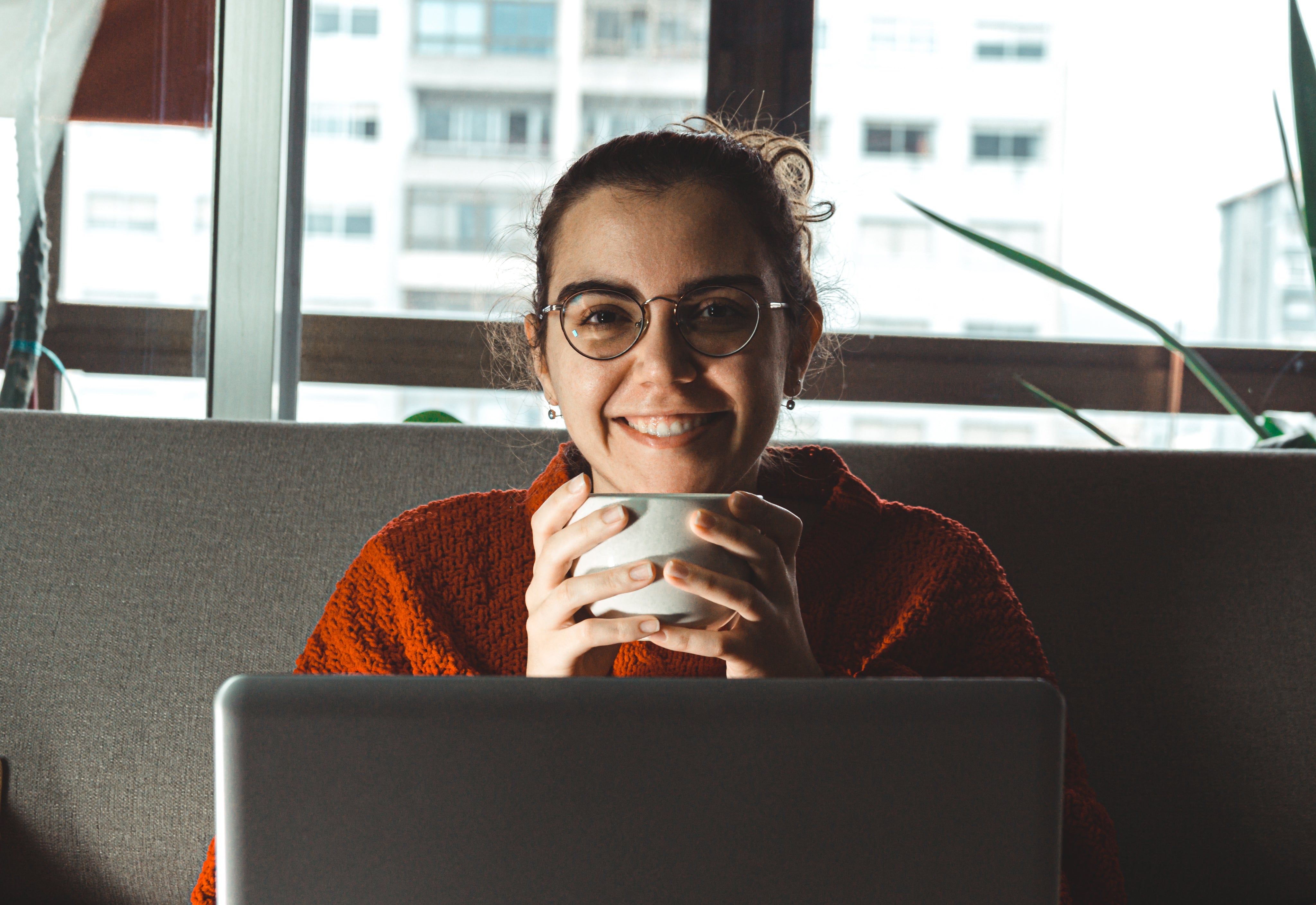 files/women-smiles-holding-mug-sitting-behind-a-laptop.jpg